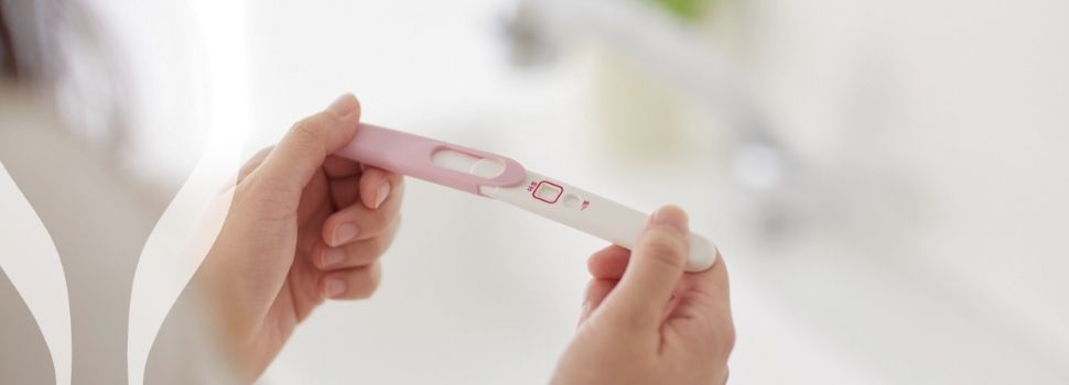 Ruce drží těhotenský test